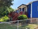 Backyard view showcasing a red wooden deck, blue siding, and chain-link fence at 455 Wood Ave, Kannapolis, NC 28083