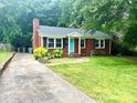 Traditional brick home with a concrete driveway and well-manicured lawn at 4906 Charleston Dr, Charlotte, NC 28212