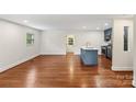 Open-concept living room with hardwood floors and a view into the kitchen at 4906 Charleston Dr, Charlotte, NC 28212