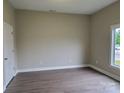 Cozy bedroom with hardwood flooring, neutral paint, and a window providing natural light at 518 N Fulton St, Salisbury, NC 28144