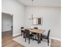Modern dining room with a stylish chandelier, sleek chairs and an area rug at 5843 Timber Falls Nw Pl, Concord, NC 28027