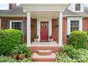 Inviting front porch with red brick steps and vibrant potted plants accentuating the charming entrance at 81 21St Nw Ave, Hickory, NC 28601