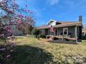 Charming home with a cozy front porch, manicured landscaping, and patriotic American flag display at 101 Sunset Dr, Stanley, NC 28164