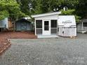 Cozy camper with screened porch, shed, and gravel lot offering a charming and convenient outdoor living space at 107 Pine St, New London, NC 28127