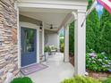 Inviting covered front porch with stone accents, comfortable seating, and a beautifully decorated entrance at 1226 Restoration Dr, Waxhaw, NC 28173