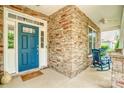 Inviting front porch features stone accents, a rocking chair, and a bright blue front door at 12910 Meetinghouse Dr, Cornelius, NC 28031
