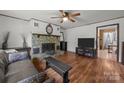 Inviting living room with stone fireplace, hardwood floors, and modern ceiling fan at 147 Hansard Dr, Charlotte, NC 28214