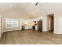 Open kitchen featuring stainless appliances, white cabinetry, granite countertops, and wood-look flooring at 153 Ole Eastpointe Dr, York, SC 29745