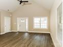 Bright living room features high vaulted ceilings, fan, wood-look flooring and white trim throughout at 153 Ole Eastpointe Dr, York, SC 29745
