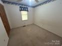 A simple bedroom with light-colored walls, carpeted floor, and a single window at 1616 Lazenby St # 17, Newton, NC 28658