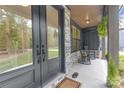 Close up of the inviting front porch, with a double door entrance and traditional rocking chairs at 18238 Youngblood N Rd, Charlotte, NC 28278