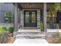 Inviting front porch with stone accents, a double door entry, and classic rocking chairs at 18238 Youngblood N Rd, Charlotte, NC 28278
