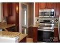 Cozy kitchen with stainless steel appliances, granite counters, and dark wood cabinetry at 19834 Davidson Concord Rd, Davidson, NC 28036