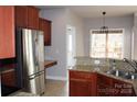 Bright kitchen featuring stainless steel appliances, granite counters, and tiled floors at 19834 Davidson Concord Rd, Davidson, NC 28036