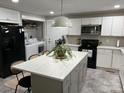 Well-lit kitchen featuring white cabinets, stainless steel appliances, a large island, and modern countertops at 199 Crowell Sw Dr, Concord, NC 28025