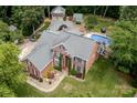 Expansive backyard featuring a sparkling pool, detached garage, and lush landscaping creates a private retreat at 2031 Brook View Ct, Matthews, NC 28104