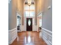 Grand foyer with soaring ceilings, hardwood floors, and transom windows over the front door at 2031 Brook View Ct, Matthews, NC 28104