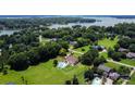 Expansive aerial view showcasing a home with a pool, set amid lush greenery and serene lakeside scenery at 205 Harwell Rd, Mooresville, NC 28117