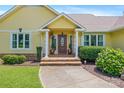 Inviting front entrance with a decorative door, stone steps, manicured bushes, and a well-maintained walkway at 205 Harwell Rd, Mooresville, NC 28117
