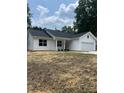 Attractive one-story home featuring white siding, a dark roof, and tidy landscaping in the front yard at 210 Johnson St, Troutman, NC 28116