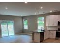 The bright kitchen boasts modern appliances, granite countertops, and a view of the backyard at 210 Johnson St, Troutman, NC 28116
