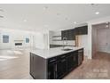 Open concept kitchen featuring black cabinets, stainless steel appliances, island and a fireplace at 220 Windy Dell Dr, Tega Cay, SC 29708