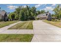 Long concrete driveway leads to a beautiful home with a well-manicured lawn and lush trees at 2245 Lincolnshire Ln, Waxhaw, NC 28173