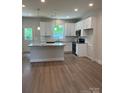 Modern kitchen featuring white cabinets, granite countertops, stainless steel appliances, and a stylish island at 242 North Ave, Troutman, NC 28166
