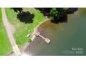 Aerial view of the lake featuring a wooden dock and green lawn at 252 Chuckwood Rd, Mooresville, NC 28117