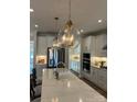 Bright kitchen with stainless steel appliances, quartz countertops, and decorative pendant lighting at 301 Supernova Dr, York, SC 29745