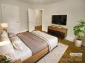 Cozy bedroom with wood-look flooring, a TV, and a window letting in natural light at 3109 Morson St, Charlotte, NC 28208