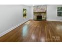Spacious living room with hardwood floors and stone fireplace, offering a bright and airy atmosphere at 3109 Morson St, Charlotte, NC 28208