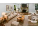 Comfortable living room featuring hardwood floors, stone fireplace and large window with backyard view at 3109 Morson St, Charlotte, NC 28208