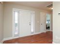 Bright entryway features hardwood floors, a white door with sidelights, and a glimpse into the bedroom at 3523 Brickwood Cir, Midland, NC 28107