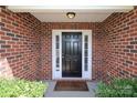 Inviting front entrance featuring brick facade, classic black door with sidelights and a 'Welcome' mat at 3523 Brickwood Cir, Midland, NC 28107
