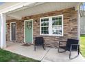 Inviting front porch with stylish chairs and a decorative wreath on the charming green door at 3965 Hemingway Dr, Hickory, NC 28601
