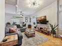 Cozy living room with large sectional, mounted TV, and ample natural light at 404 N Laurel Ave # 11, Charlotte, NC 28204