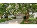Home exterior with white garage door, mature trees, and a well-manicured lawn at 424 Paperbark Ln, Rock Hill, SC 29732