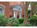 Charming brick building entrance featuring white columns and mature landscaping at 5601 Fairview Rd # 11, Charlotte, NC 28209