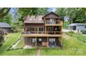 Brown exterior lake house with two wooden decks, surrounded by a lawn and mature trees at 6719 Love Point Rd, Denver, NC 28037