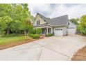 Inviting home with a spacious driveway, well-maintained lawn, and attached garages at 7101 Weavers Run, Cramerton, NC 28032