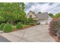 Inviting home with a spacious driveway, well-maintained lawn, and attached garages at 7101 Weavers Run, Cramerton, NC 28032