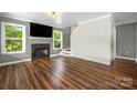 Cozy living room with a fireplace, wood floors, and bright natural light at 7101 Weavers Run, Cramerton, NC 28032