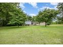 Single-story home with a spacious front yard, mature trees offering shade, and a well-maintained lawn at 985 Needmore Rd, Woodleaf, NC 27054