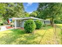 Landscaped lawn, mature trees, and a charming exterior create a welcoming atmosphere at 112 Lineberger St, Stanley, NC 28164