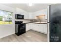 Bright kitchen with white cabinets, black appliances, and a stylish backsplash creating a modern culinary space at 112 Lineberger St, Stanley, NC 28164
