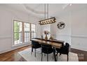 Dining room with dark hardwood floors, wainscoting, and contemporary lighting fixtures at 11841 Churchfield Ln, Charlotte, NC 28277