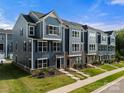 Attractive gray townhomes featuring meticulous landscaping and stylish architectural details at 120 August Ln, Stallings, NC 28104