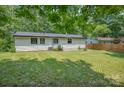 Rear view of home showing a well maintained vinyl exterior and a spacious lawn with green grass at 1214 Northwoods Dr, Kings Mountain, NC 28086
