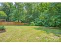 Large fenced-in backyard with lush green grass and mature trees, offering privacy and space at 1214 Northwoods Dr, Kings Mountain, NC 28086
